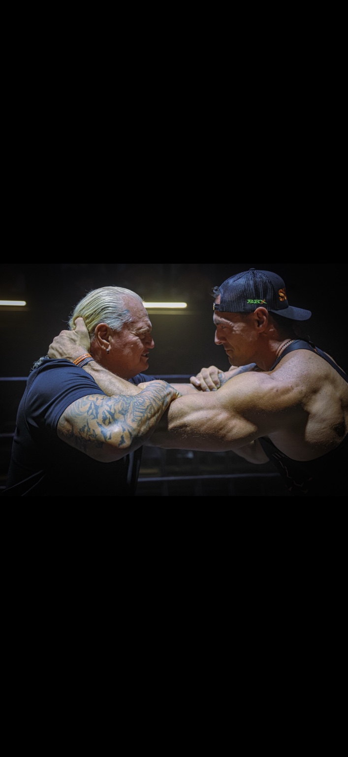 Two wrestlers working together at ringside